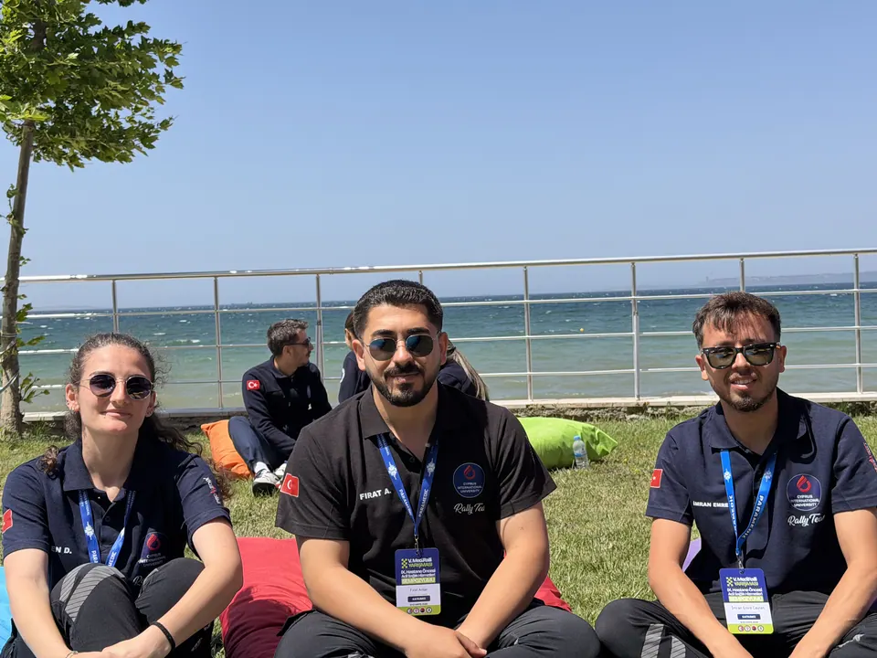 Deniz kenarında oturan üç kişilik takım