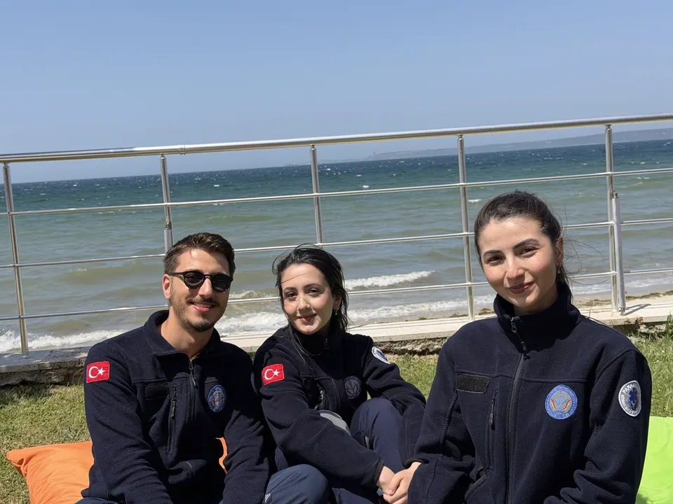 Gülümseyen lacivert formalı üç yarışmacı