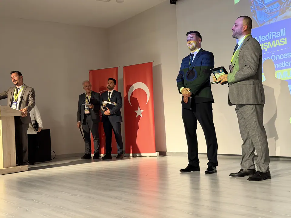 Ödül töreninde sahnede plaket alan katılımcı
